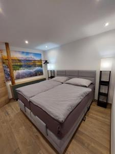 a bedroom with a bed with a painting on the wall at Appartements Emilia in Ehrwald
