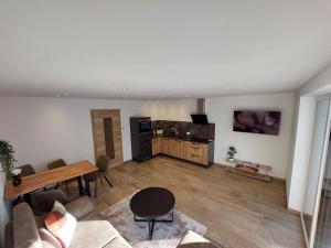 a living room with a table and a kitchen at Appartements Emilia in Ehrwald