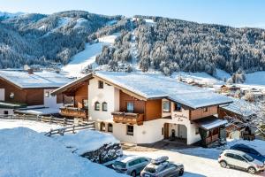 ein Haus im Schnee mit Autos vor dem Haus in der Unterkunft Ferienhaus Eva in Flachau