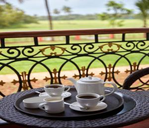 a table with two cups and saucers on top of it at Sea Queen Beach Resort & Spa in Colva