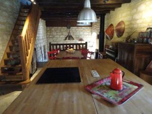 un tavolo in legno con un bollitore rosso sopra di l'Ancienne Ecole de Rocamadour dans le Lot a Rocamadour Altre 27 foto