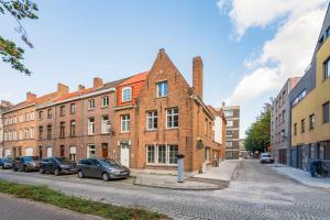 an old brick building on a street with parked cars at De Hoogmolen - 3 mins from the city centre in Bruges