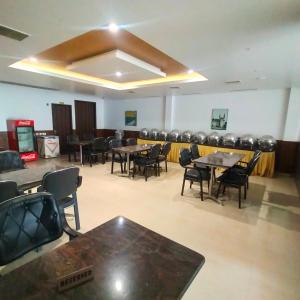 una habitación con mesas y sillas y una fila de sillas en JB Residency en Tiruchchirāppalli