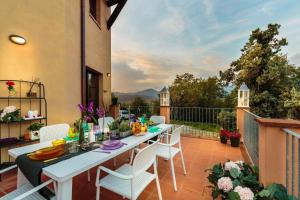 eine Terrasse mit einem Tisch und Stühlen auf dem Balkon in der Unterkunft Kinzia FARMHOUSE APARTMENT close to Lucca Walls in Lucca