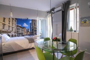 einen Glastisch in einem Zimmer mit einem Bett und einem Schlafzimmer in der Unterkunft Central apartment close to food and shopping in Bologna