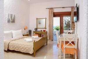 a bedroom with a bed and a table and a mirror at Amatu Villa (Hermes) in Xerokampos