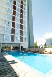 a swimming pool in front of a tall building at Petro Hotel in Vung Tau