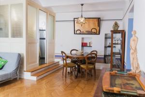 sala de estar con mesa, sillas y sofá en Monti Art Déco - design apartment, en Roma