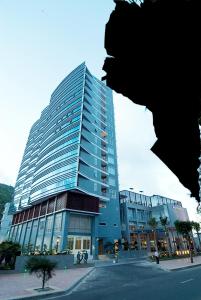 un edificio azul alto con gente delante de él en Petro Hotel, en Vung Tau