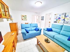 a living room with blue couches and a table at Dunas y Luz in Rota
