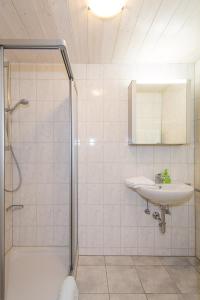 a white bathroom with a sink and a shower at Ferienwohnung Plenk inkl. Chiemgaukarte in Ruhpolding