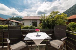 a table with a vase of flowers on a balcony at Ferienwohnung Plenk inkl. Chiemgaukarte in Ruhpolding