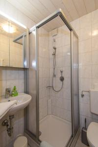 a bathroom with a shower and a toilet and a sink at Ferienwohnung Plenk inkl. Chiemgaukarte in Ruhpolding +16 photos