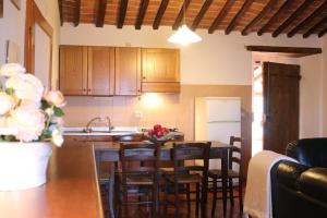 een keuken met houten kasten en een tafel met stoelen bij Villa Cenerentola in Trequanda