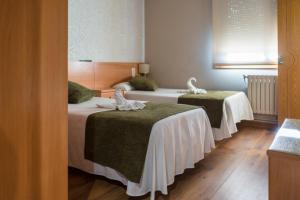 um quarto de hotel com duas camas com toalhas em Pensión Capitan em Aldán