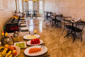 a buffet line with plates of food and tables and chairs at Pousada Aurora in Alto Paraíso de Goiás