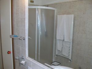 uma casa de banho com um chuveiro, um lavatório e um WC. em Hotel Santorotto em Sinalunga