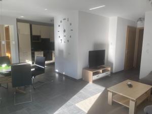 a living room with a television and a table at Apart Kathrin in Fliess