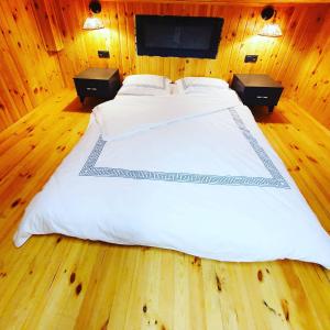 a large white bed in a wooden room at SAPANCA MİNİK EVLER in Sapanca