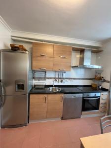 a kitchen with stainless steel appliances and wooden cabinets at Salinas al Mar in Salinas