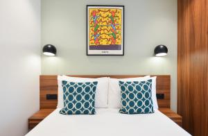 a bedroom with a bed with blue and white pillows at Shepherds Bush Green Serviced Apartments by Concept Apartments in London