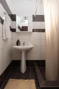 W łazience znajduje się umywalka i lustro. w obiekcie Serenity House w mieście Ágios Matthaíos