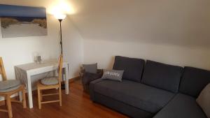 a living room with a couch and a desk at Ferienwohnung-Haus Holly in Uetersen