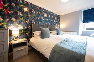 a bedroom with a bed with a floral wallpaper at Templehall Hotel in Morebattle