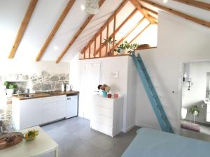 una cocina con armarios blancos y una escalera azul en Guest House Maris, en Split