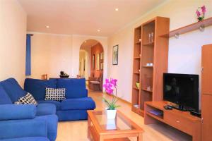 a living room with a blue couch and a tv at Tramuntana 2 1 Roses- Immo Barneda in Roses
