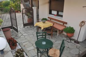 a patio with a table and chairs and a bench at GUESTHOUSE BLOUTSOS ROOMS in Kastraki