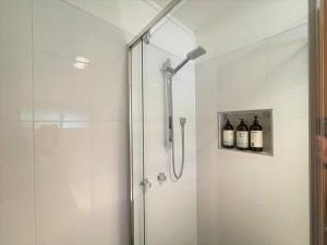 a shower with three bottles of wine in a bathroom at Apollo bay Holiday House in Apollo Bay +18 photos