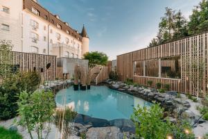 uma piscina num quintal ao lado de um edifício em Wellness Hotel SEN em Senohraby