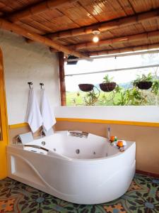 a large white bath tub in a room with a window at FINCA HOTEL DON JULIO in Santa Rosa de Cabal