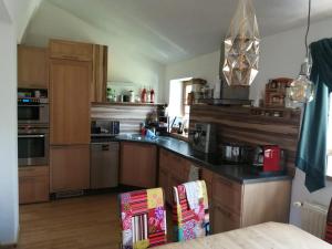 a kitchen with wooden cabinets and a black counter top at Apartment Nazbauerhof in Rohr im Gebirge