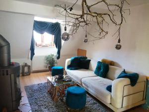 uma sala de estar com um sofá branco e almofadas azuis em Apartment Nazbauerhof em Rohr im Gebirge