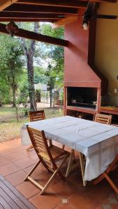 einen Tisch und Stühle auf einer Terrasse mit Kamin in der Unterkunft Ventana a la Selva Casa Residencial in Eldorado