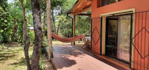 un'amaca è appesa al lato di una casa di Ventana a la Selva Casa Residencial a Eldorado