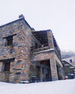 um edifício de pedra na neve com neve em Giataki em Caristo