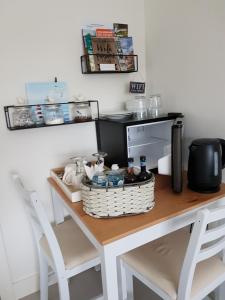 a kitchen table with two chairs and a table with a basket on it at Petite Anchorage in Christchurch +7 photos