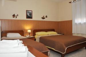 een hotelkamer met 2 bedden en een raam bij GUESTHOUSE BLOUTSOS ROOMS in Kastraki