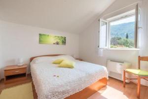 ein weißes Schlafzimmer mit einem Bett und einem Fenster in der Unterkunft Villa Panorama Dubrovnik in Mlini