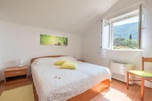 a white bedroom with a bed and a window at Villa Panorama Dubrovnik in Mlini