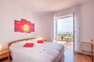 ein weißes Schlafzimmer mit Bett und Balkon in der Unterkunft Villa Panorama Dubrovnik in Mlini