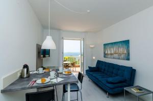 a living room with a blue couch and a table at Villa Panorama Dubrovnik in Mlini