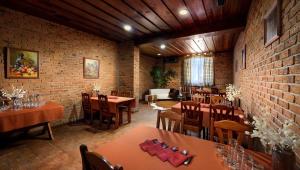 a restaurant with tables and chairs and a brick wall at Penzion Pod zámkom-Boleráz in Boleráz