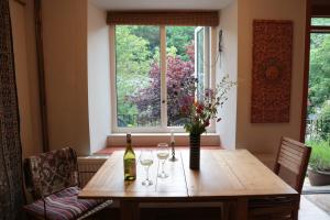 a dining room table with wine glasses and a window at Beautiful quiet room in the heart of Holmfirth in Holmfirth