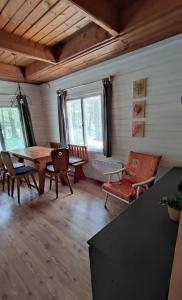 een woonkamer met een houten tafel en stoelen bij Chatky u potoka - chatička č.2 in Olešnice v Orlických horách