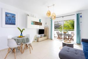 - un salon avec une table et un canapé dans l'établissement Home2Book Stunning Apartment Bajamar, à Bajamar