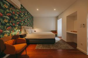 a bedroom with a bed and a floral wall mural at Azores Inn - Family Suites in Ponta Delgada
